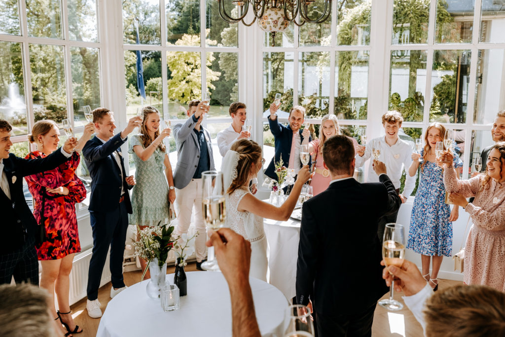 Proost moment van bruid en bruidegom en gasten met champagne