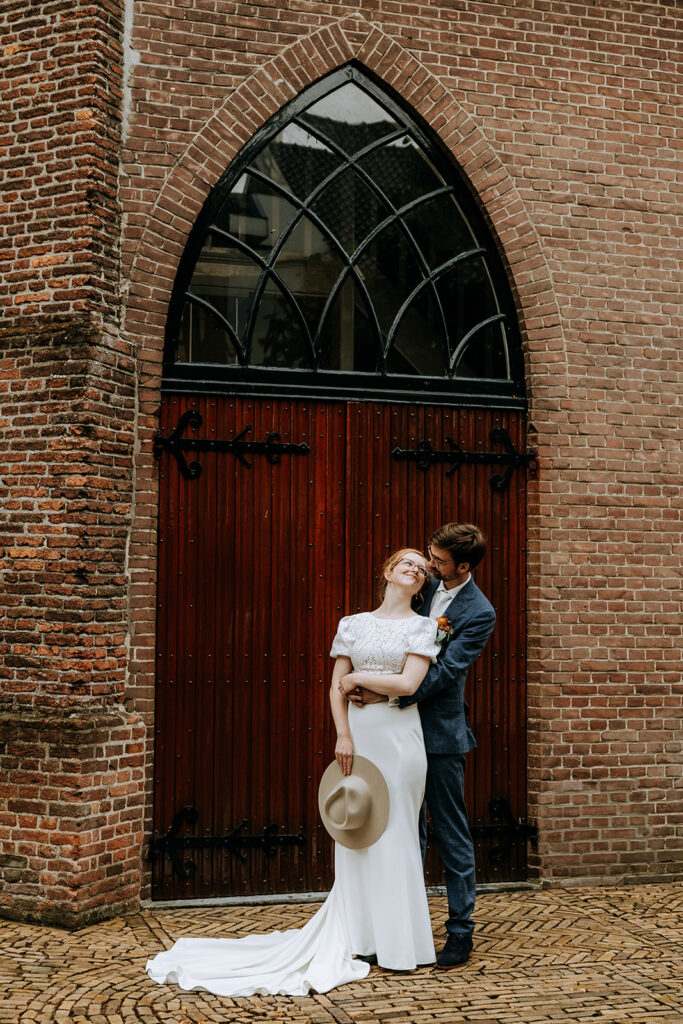 Bruid en bruidegom voor de deur van de kerk