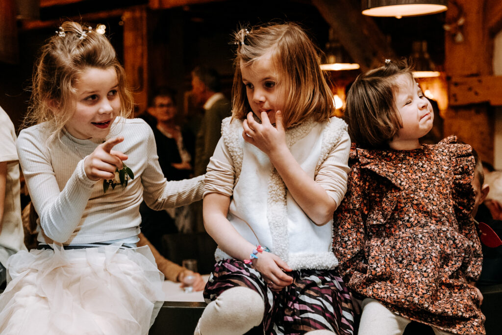 Drie bruidskinderen op bankje vervelen zich