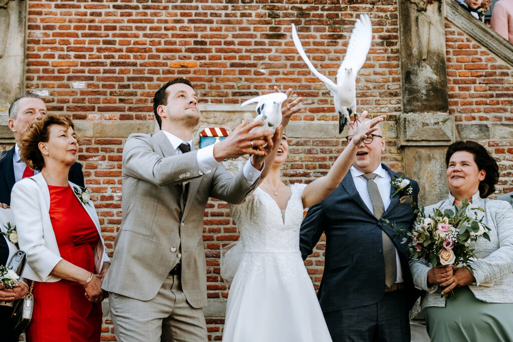 Bruid en bruidegom laten twee witte duiven los na de ceremonie