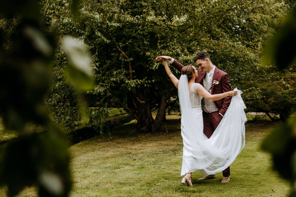 Bruid en bruidegom dansen samen op een grasveld in een park in Rotterdam