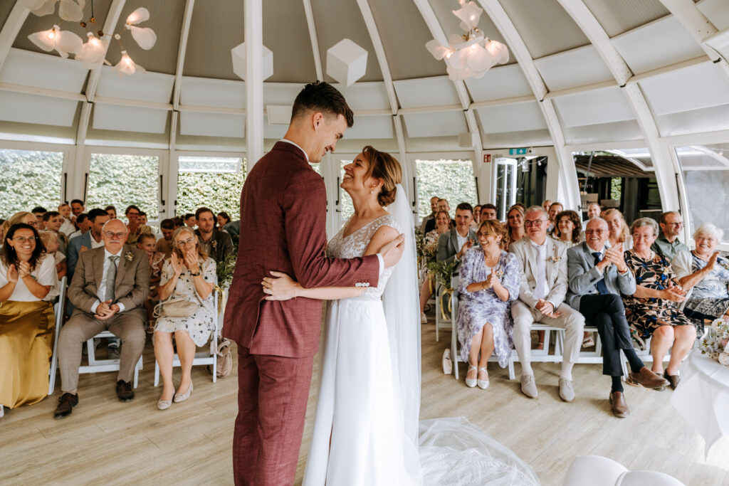 Bruid en bruidegom hebben elkaar het jawoord gegeven en alle gasten geven applaus