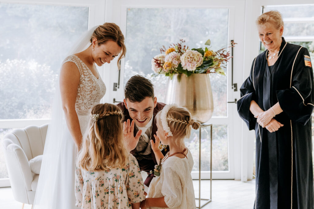 Bruidskinderen krijgen high five van de bruidegom na het geven van de ringen