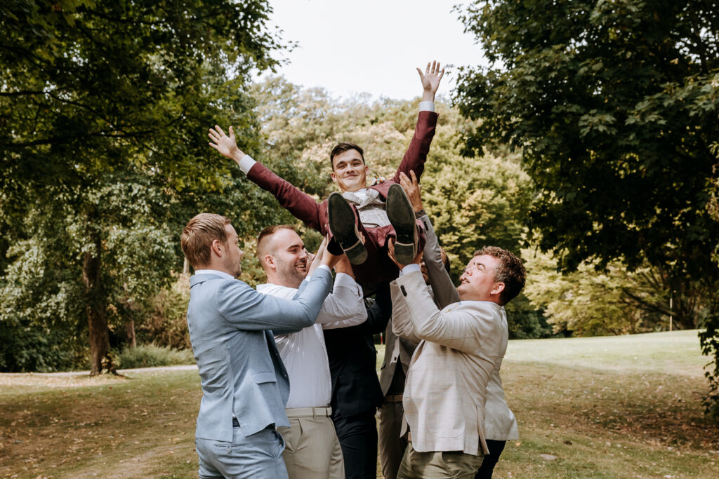 Bruidegom wordt in de lucht gegooid door zijn vrienden