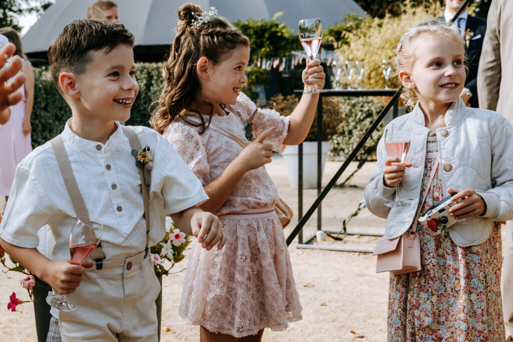 Kinderen op bruiloft proosten met kinderchampagne
