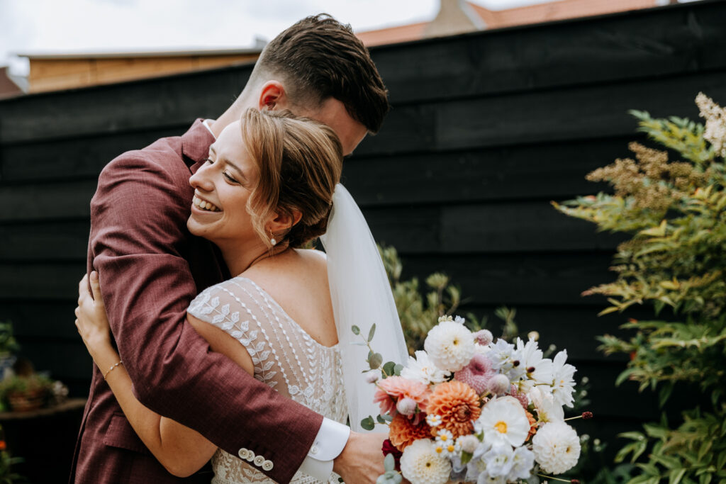 Bruid en bruidegom knuffelen tijdens de first look