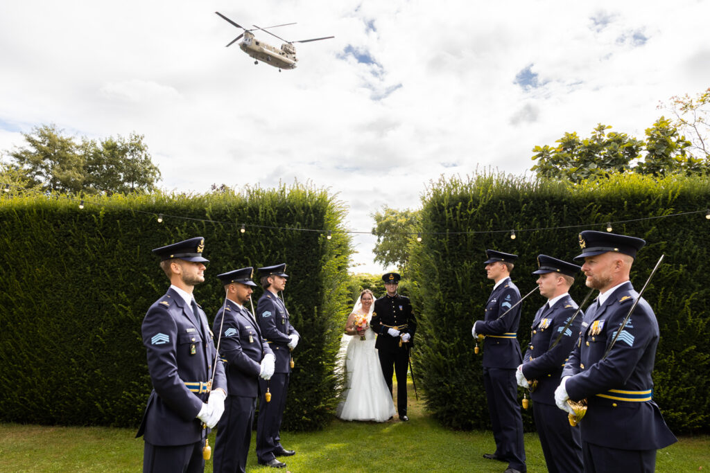 Een heel persoonlijk moment: het bruidspaar loopt richting sabelwacht, terwijl een Chinook overvliegt