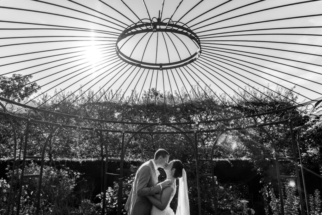 Bruidspaar kust elkaar onder een grote grafische koepel
