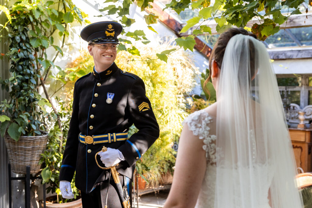 Bruid en bruidegom zien elkaar nadat de bruidegom zijn uniform heeft aangedaan