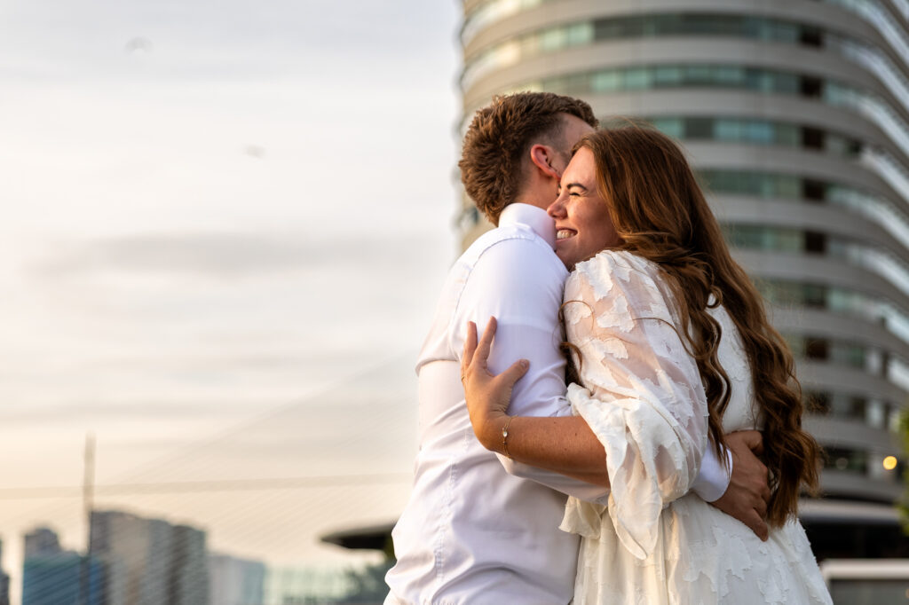 Aanstaand bruidspaar in Rotterdam op de Kop van Zuid omhelst elkaar tijdens golden hour