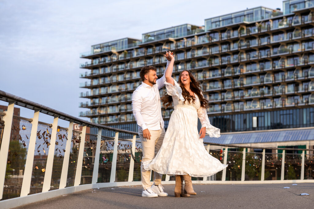 Bruidspaar in Rotterdam tijdens preweddingshoot, dansend op de slottjesbrug tijdens golden hour